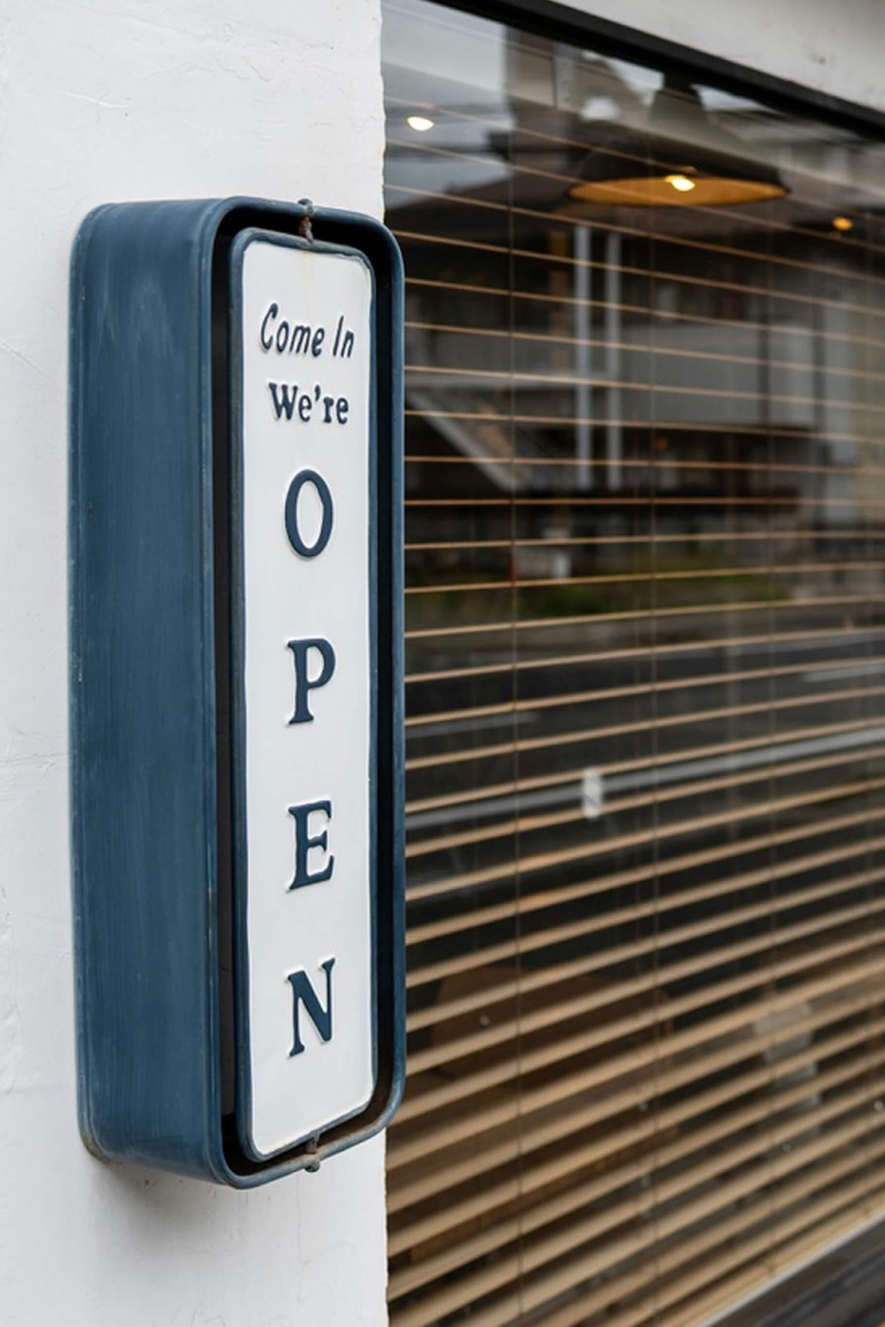 Offene Tür mit einem „Come in, we're open“-Schild